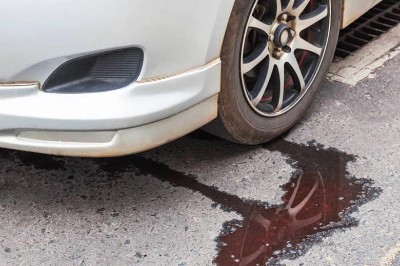 Carro estacionado sobre uma mancha de óleo