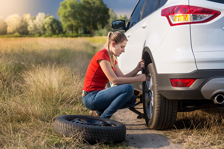 Condutora trocando o pneu do seu carro